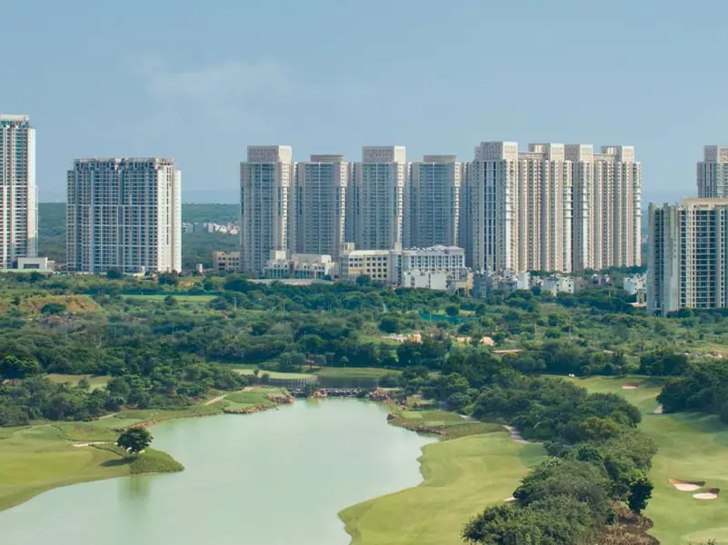 Aerial view of DLF The Crest residential area in Gurgaon, featuring landscaped gardens, swimming pool, and modern towers.
