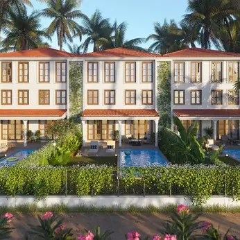 A serene morning view of a traditional Goan sloped-roof villa balcony overlooking green fields and a private garden.